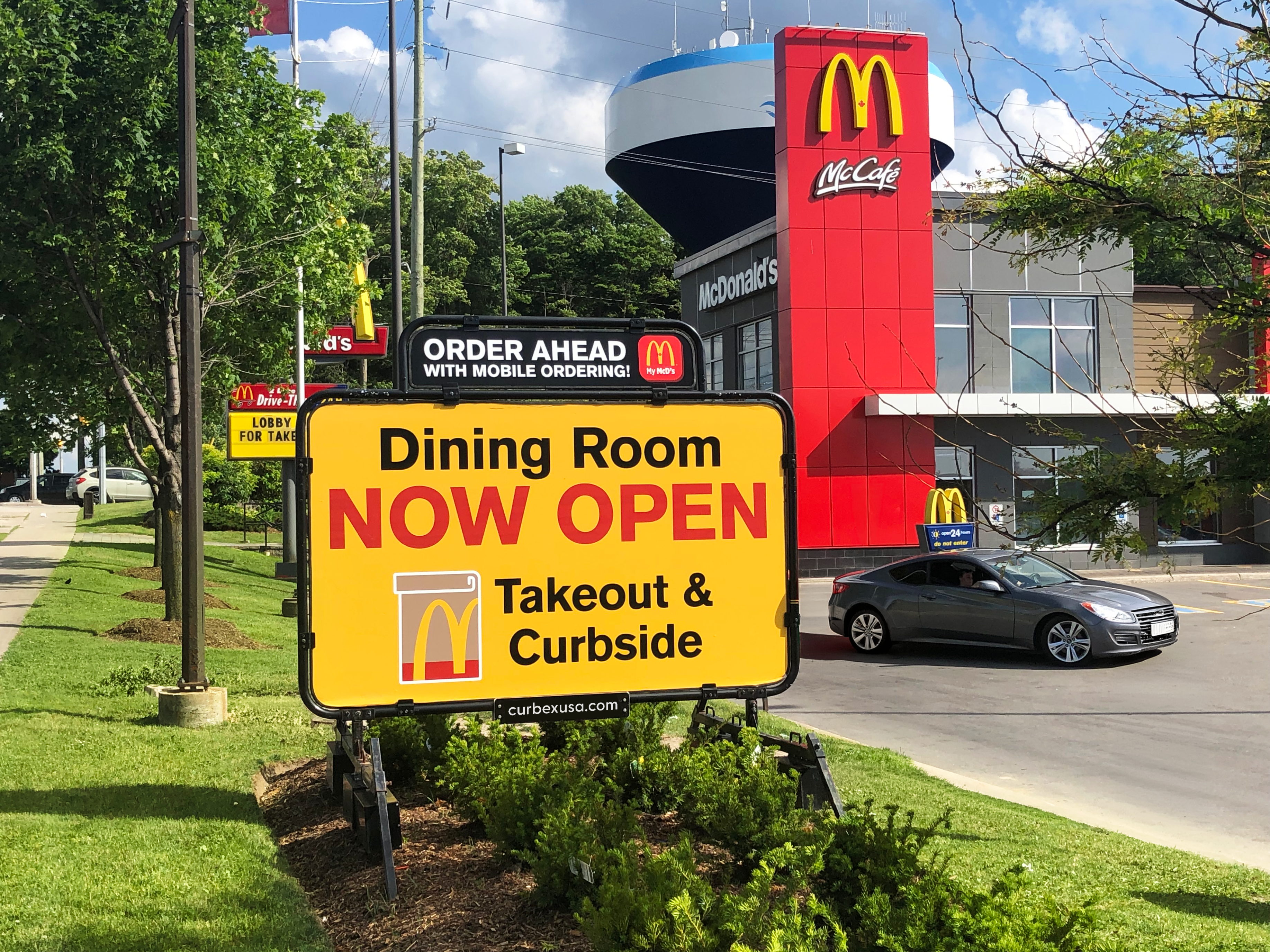 Curbex sign displaying Bloom Smoothie Bar promotion on a plaza